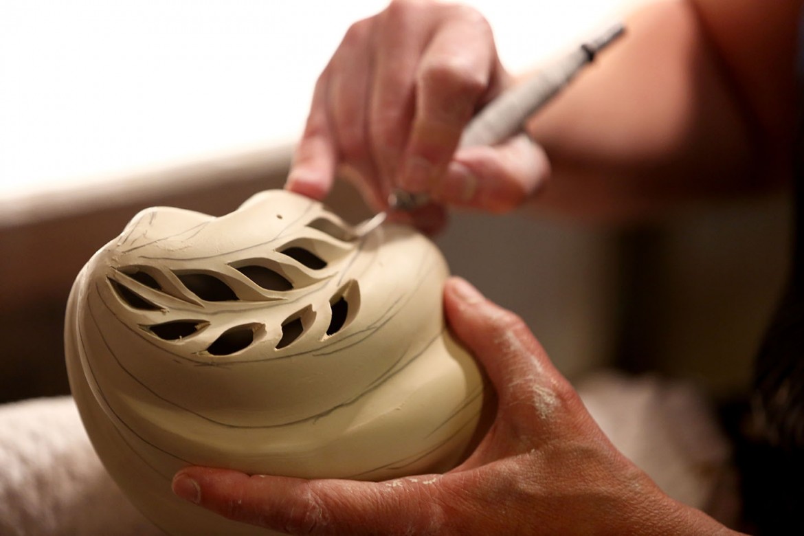 Carefully cutting out leaf-shaped pieces from the porcelain.